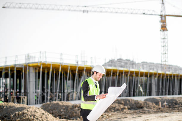 istock Side view of young construction engineer man with projects and hard hat 1183798640