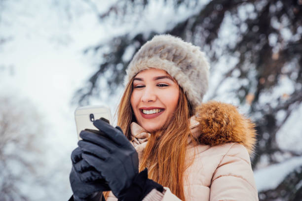 istock Young woman texting at the winter park 1183798776