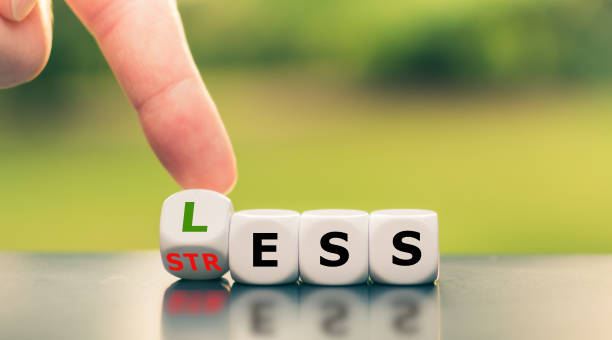 istock Having less stress or being stress-less. Hand turns a cube and changes the word 