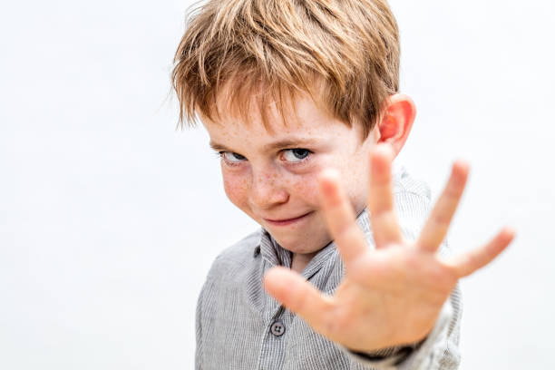 determined smiling boy with his hand forward to show his boundaries or playing give me five, isolated white background