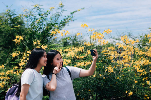istock Asian Twin Sisters Taking Selfie Photos While Travelling Outdoors Together 1183802390