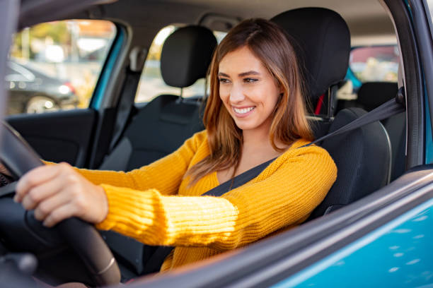 istock Young beautiful girl with a nice smile driving a car 1183802467