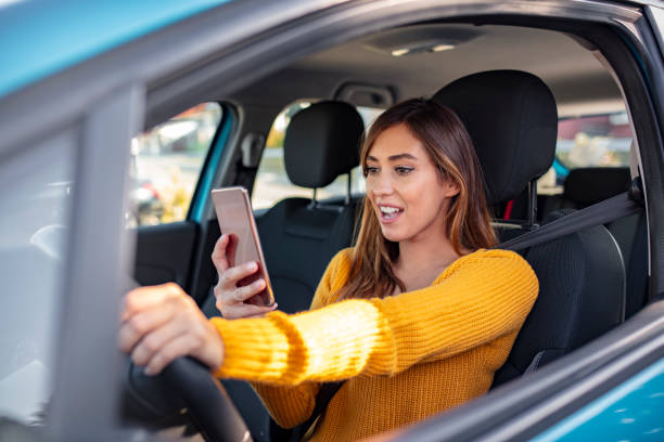 mujer conduciendo coche distraído por su teléfono móvil - driving text messaging accident car fotografías e imágenes de stock