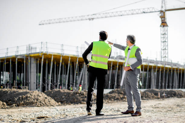 trabajadores de la construcción, supervisor o ingeniero hablan en el lugar de trabajo - promotor inmobiliario fotografías e imágenes de stock