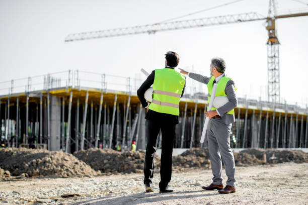 Construction workers, supervisor, or engineer talk at job site stock photo