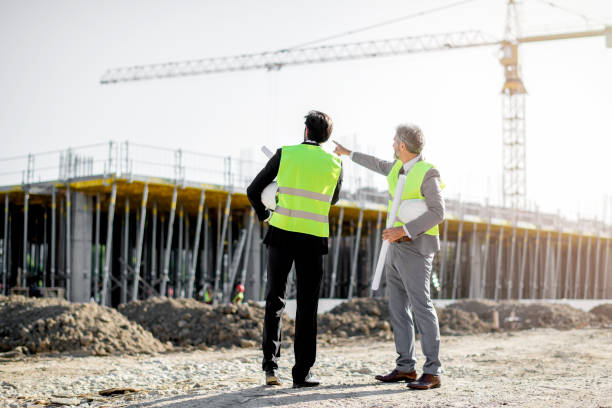 los arquitectos e ingenieros en el sitio de construcción verifican documentos y flujo de trabajo empresarial - promotores contrucion fotografías e imágenes de stock