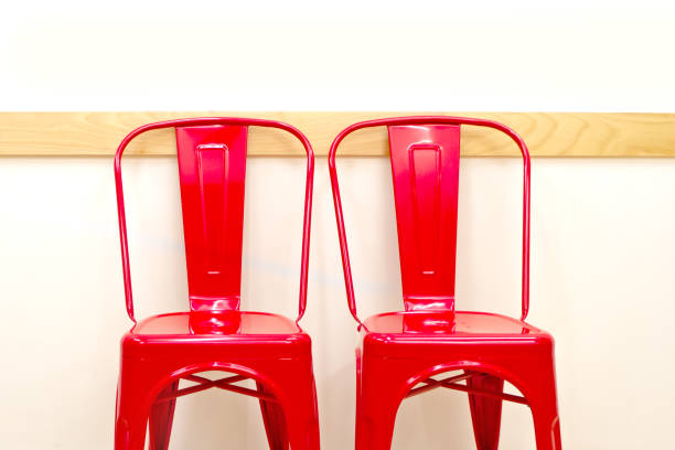 istock A pair of red metal chairs on beige wall 1183808832
