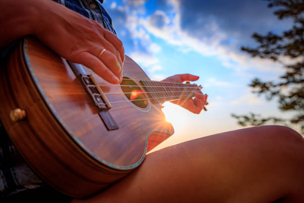 istock Woman at sunset holding a ukulele 1183808833