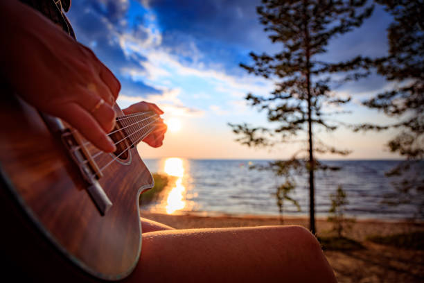 istock Woman at sunset holding a ukulele 1183808843