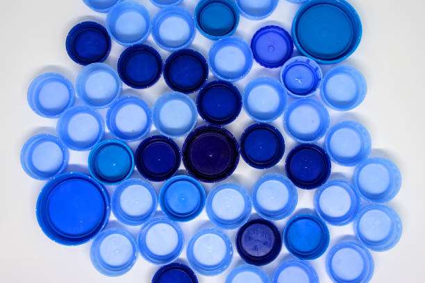 istock Dark and light blue plastic bottle caps on white background. Flat lay, view from above 1183809020