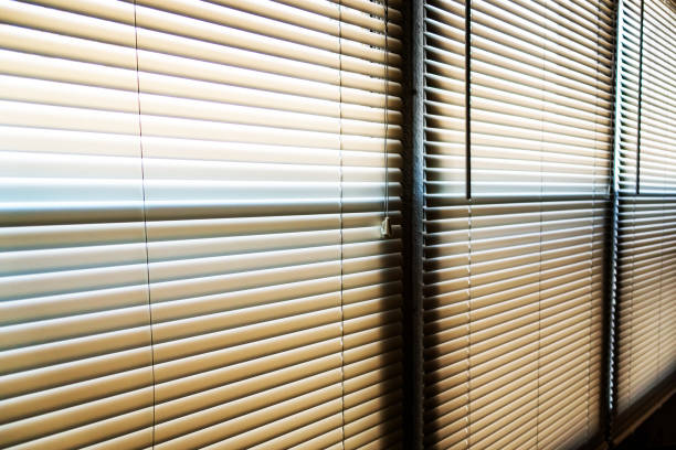 istock Sunshine hitting closed window blinds in the early morning 1183809748