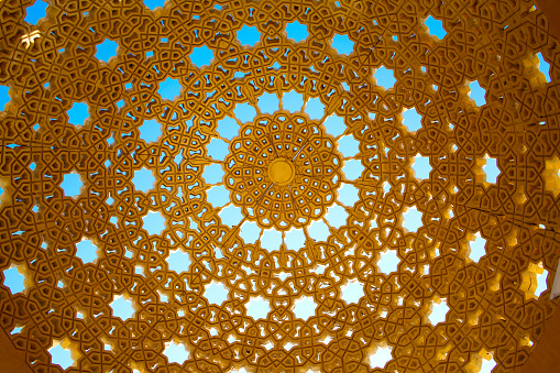 Diseño de techo la cúpula de un asiento público, de color dorado con estrellas cortadas y otras formas geométricas. Sería un fondo hermoso. Mascate, Omán. photo