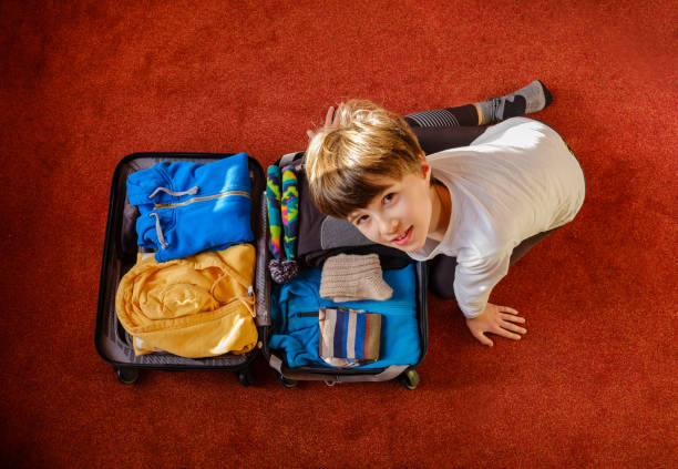 istock The child prepares the suitcase 1183810170