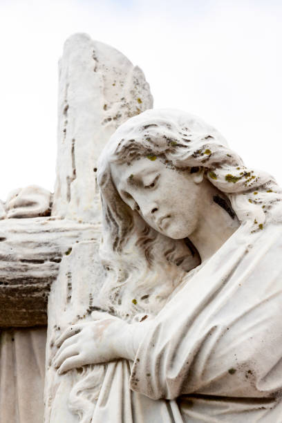 istock Angel with cross, old statue of angle, background with copy space 1183812182