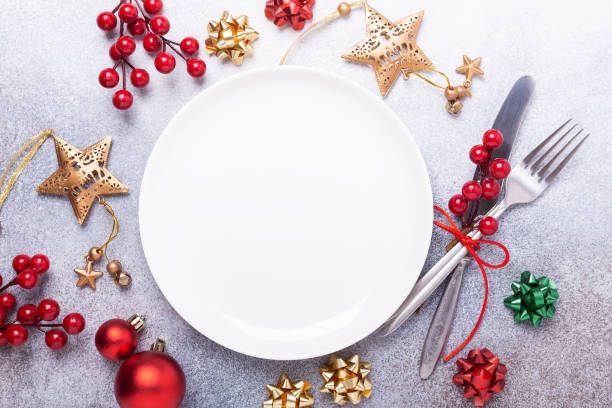 istock Christmas table place setting with empty white plate, cutlery with festive decorations on stone background 1183813171