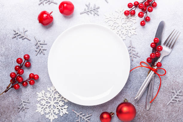 istock Christmas table place setting with empty white plate, cutlery with festive decorations on stone background 1183813212
