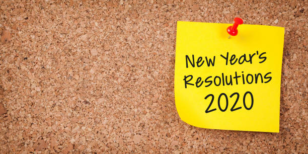 istock Yellow Sticky Note With New Year 2020 Resolutions And Red Push Pin On Cork Board 1183813931