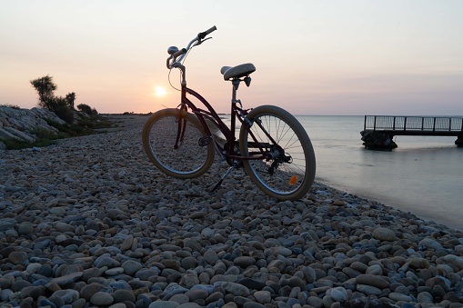 Bicycle at sunrise next to sea