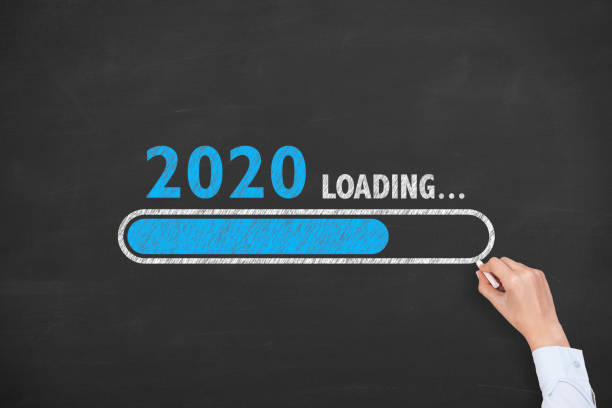 istock Human Hand Drawing Loading New Year 2020 on Chalkboard Background 1183814729