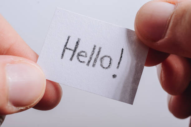 istock Hand holding notepaper with HELLO wording on white 1183815022