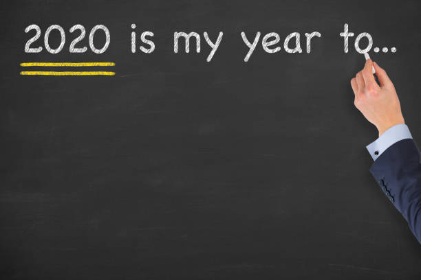 istock Human hand drawing 2020's my year to... on blackboard background 1183815182