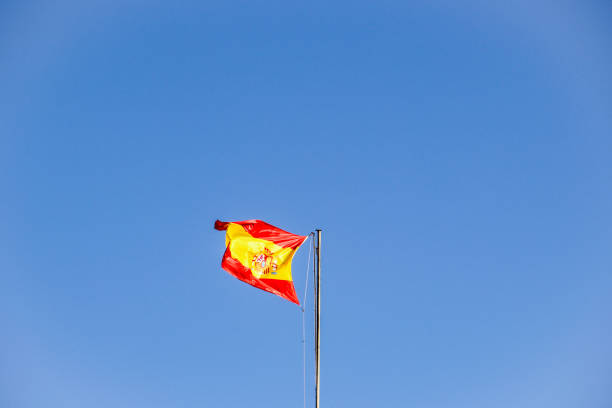 spanische flagge an einer stange in spanien - spain flag built structure cloud stock-fotos und bilder