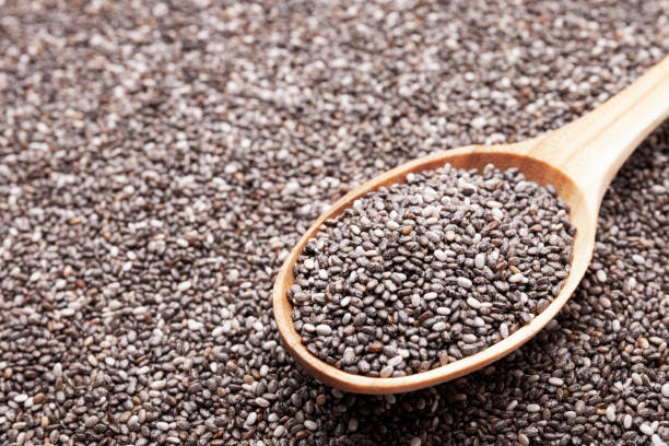 istock Chia seeds in wooden spoon isolated on white background 1183816636