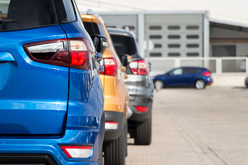 Madrid, Spain - September 7, 2019. Back of blue, yellow and gray Ford ecosport cars in a row in showroom. Ford is an American multinational automaker