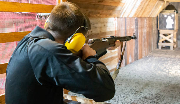 boy on the shooting range aiming an old rifle at the target stock photo