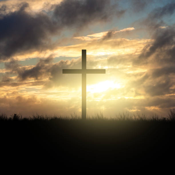 istock Cross silhouette at sunset sky 1183821342