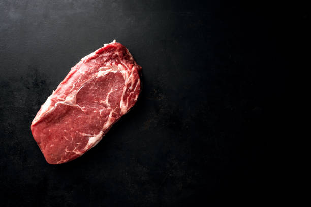 Raw beef steak with ingredients on table