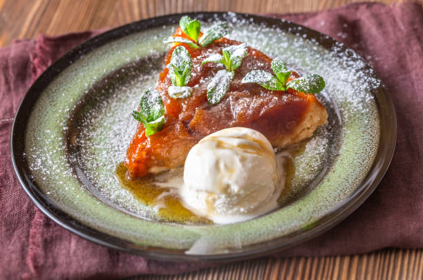 Portion of tarte Tatin Portion of tarte Tatin decorated with fresh mint and served with ball of ice-cream ice pie stock pictures, royalty-free photos & images