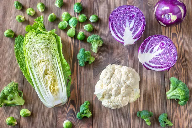 Assortment of different Cruciferous vegetables on the wooden background