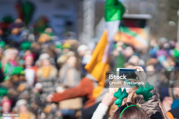 Hands Of Girl With Mobile Phone Making Photo Of Carnival Of St Patricks Day Traditional Carnival Party On A Smartphone Stock Photo - Download Image Now