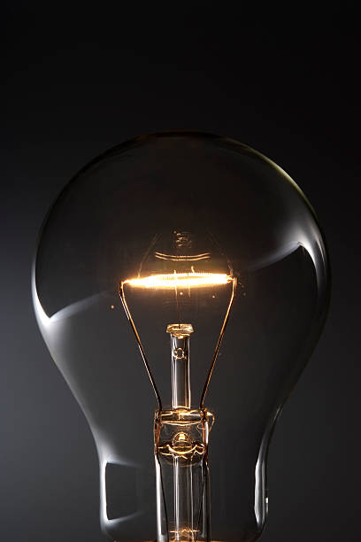 istock Close-up of illuminated light bulb against black background 118382694