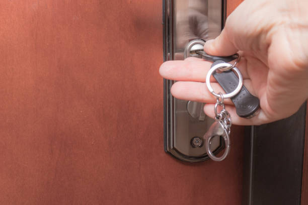 istock Woman hands locking up or unlocking front entrance doorwith a key 1183830131
