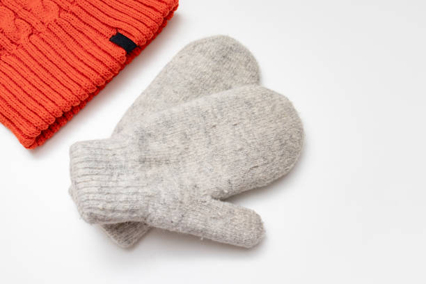 istock Orange knitted hat and warm winter mittens on white background 1183831050
