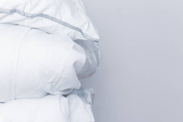 istock Pile of white bedding items, pillows and a blanket on white background with copy space 1183831161