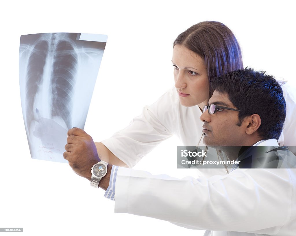 Doctors consult over an X-ray Young doctors checking an roentgen-lunge exposure Activity Stock Photo