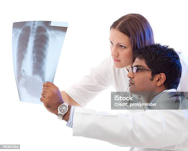 Doctors Consult Over An Xray Stock Photo - Download Image Now - Activity, Adult, Assistance