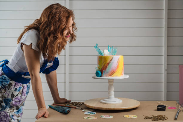 istock Woman inspecting her cake creation 1183835663