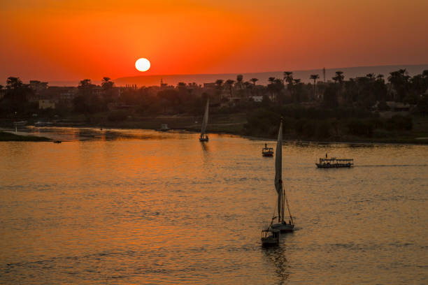 The nineties. Silhouette of a tourist, who enjoys the sunset at the edge of the Nile river. The image were scanned from old negative.