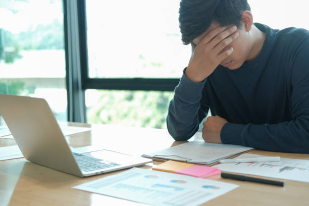 istock man feeling tired, frustrated stressed from hard work. exhausted freelancer have headache 1183845937