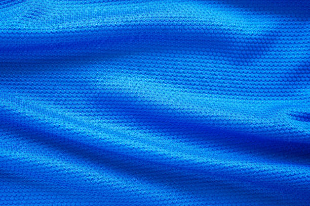 Blue football jersey clothing fabric texture sports wear background, close up top view Blue football jersey clothing fabric texture sports wear background, close up top view jersey fabric photos stock pictures, royalty-free photos & images