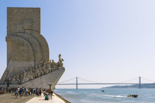 Lisbon, Portugal â august, 2019. Tourists at the monument to the Discoveries in Lisbon, is on the banks of the Tagus river and in the background you can see the 25 de Abril (25 April) bridge