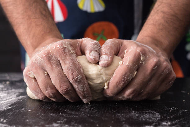istock Male hands kneading dough, baking preparation closeup. 1183846491