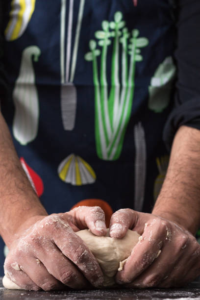 istock Male hands kneading dough, baking preparation closeup. 1183846496