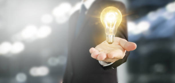 istock Hand of holding illuminated light bulb 1183857322