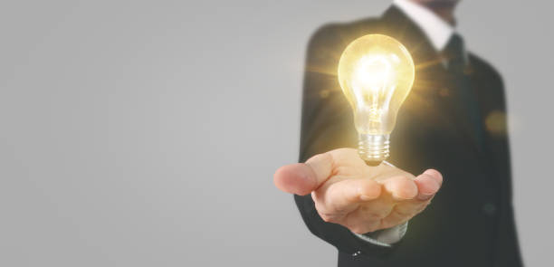 istock Hand of holding illuminated light bulb 1183857333