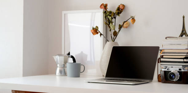istock Minimal workspace with laptop computer, camera, office supplies and dry roses vase 1183864950
